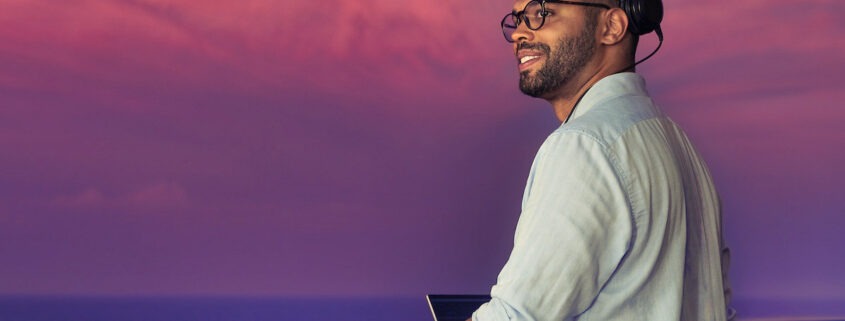 DJ playing a set on the decks of Explora one at twilight. Beautiful sky behind him